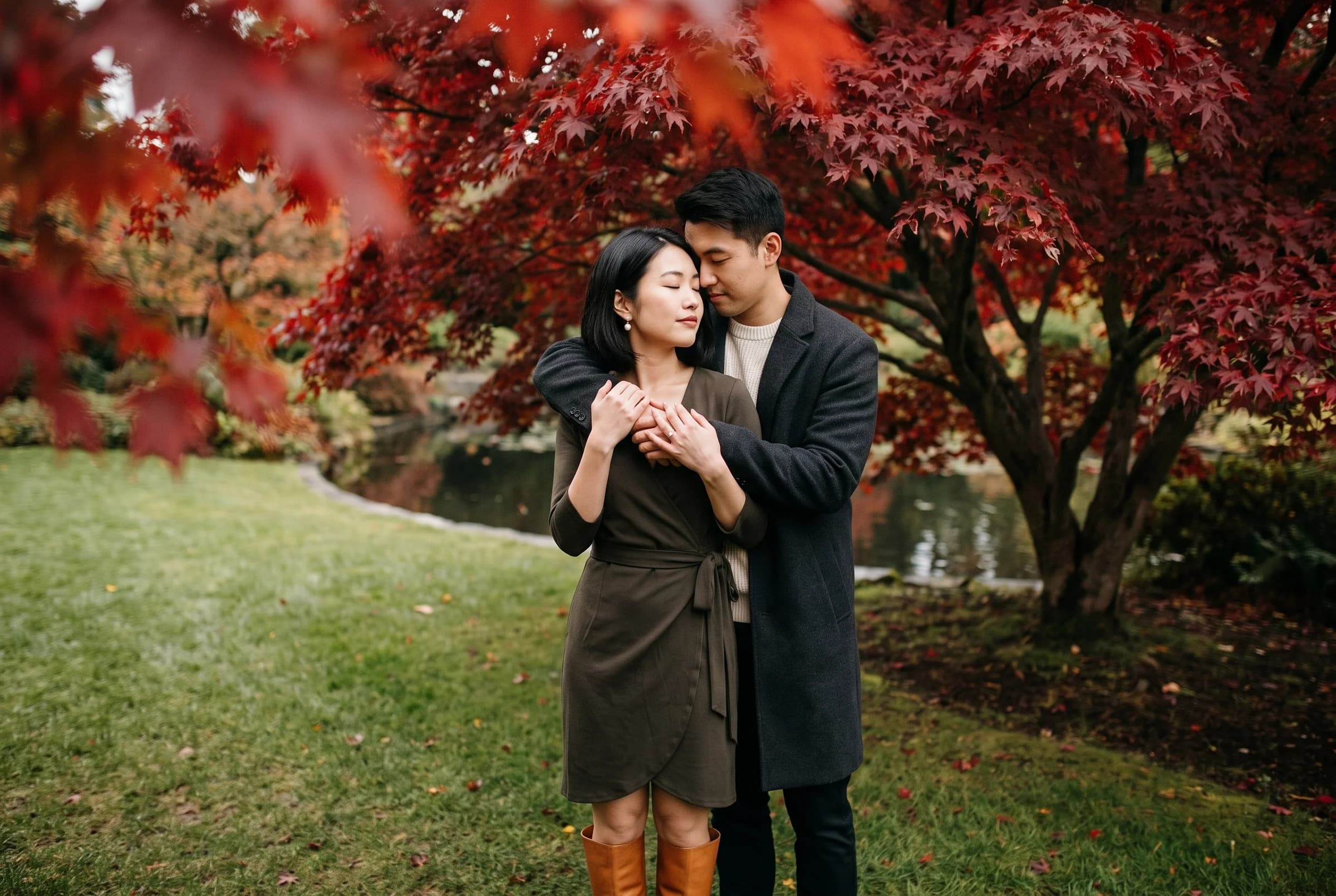 Couple standing beneath a scarlet Japanese maple at VanDusen Botanical Garden in autumn